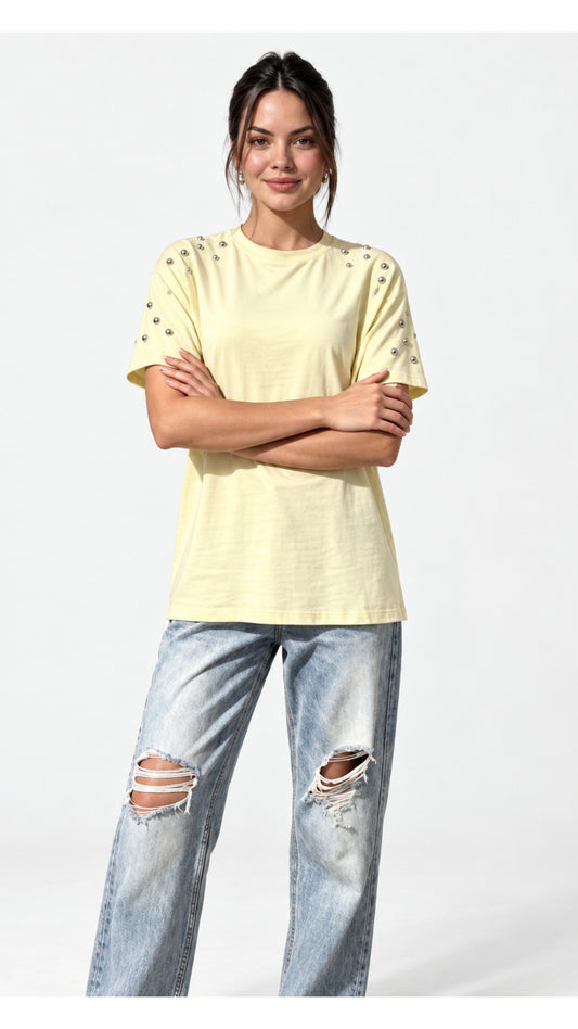 Polera amarilla con aplicaciones de tachas metálicas